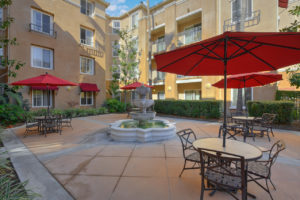 outdoor space with tables and chairs and a fountain in the center