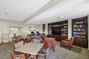 community tv room with lounge area and tables