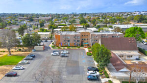 Aerial Exterior, View st. johns manor, parking lot, and surrounding areas. photo taken on a sunny day.