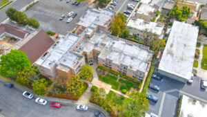 Aerial Exterior of St. Johns Manor and parking lot. 3 stories, meticulous lush landscaping around the complex.