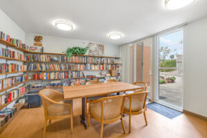 Interior Library, doors to the courtyard, 6 seats around a large table in the center of the library.