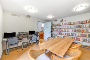 Interior Library, 2 computer stations with printer, 6 seats around a large table in the center of the library.